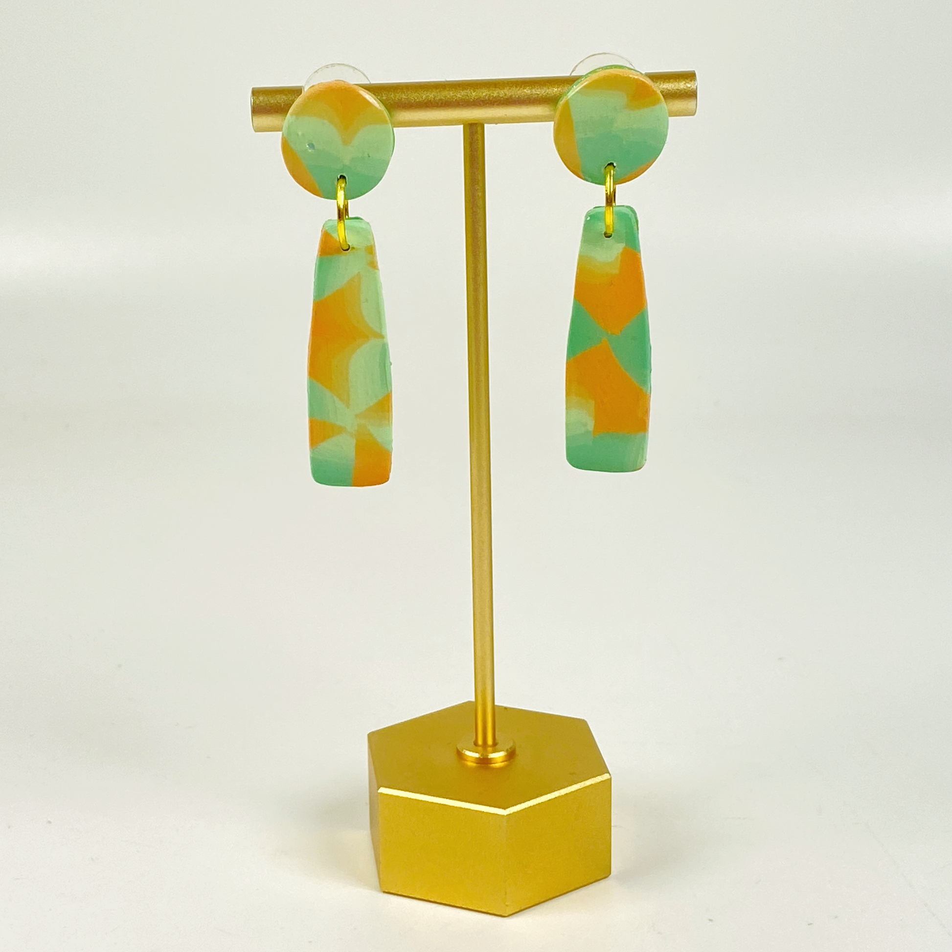 Desert Dangle Earrings on a brass earring stand.