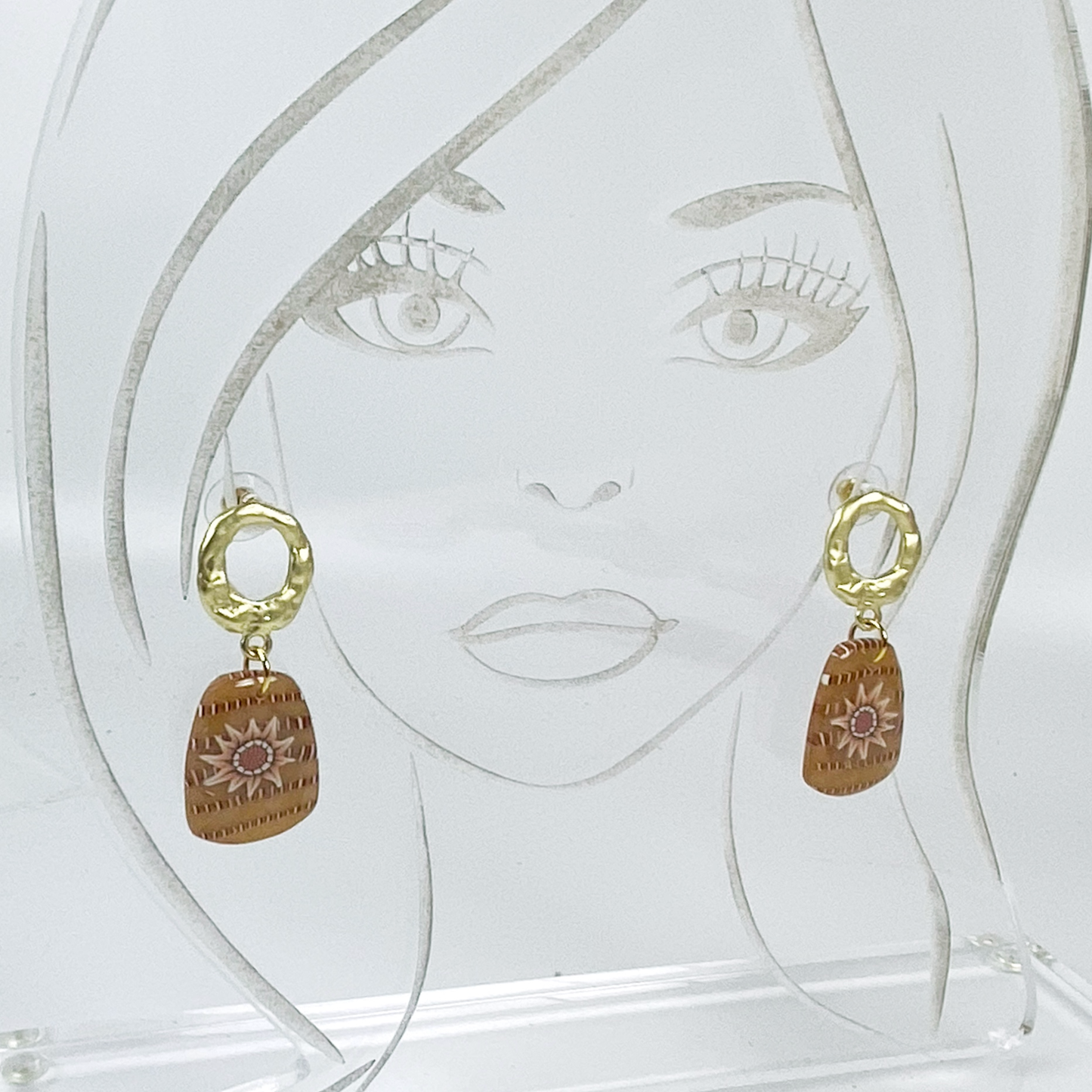 Saffron Daisy Polymer Clay Earrings on an acrylic display head.