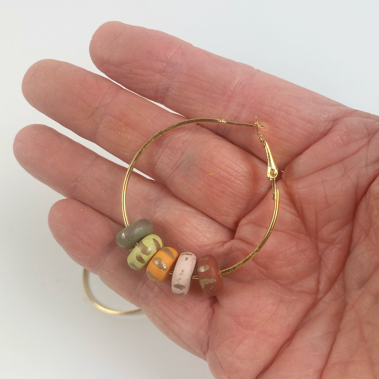 Handmade Polymer Clay Hoop Earrings with Autumn Beads handhld for size reference