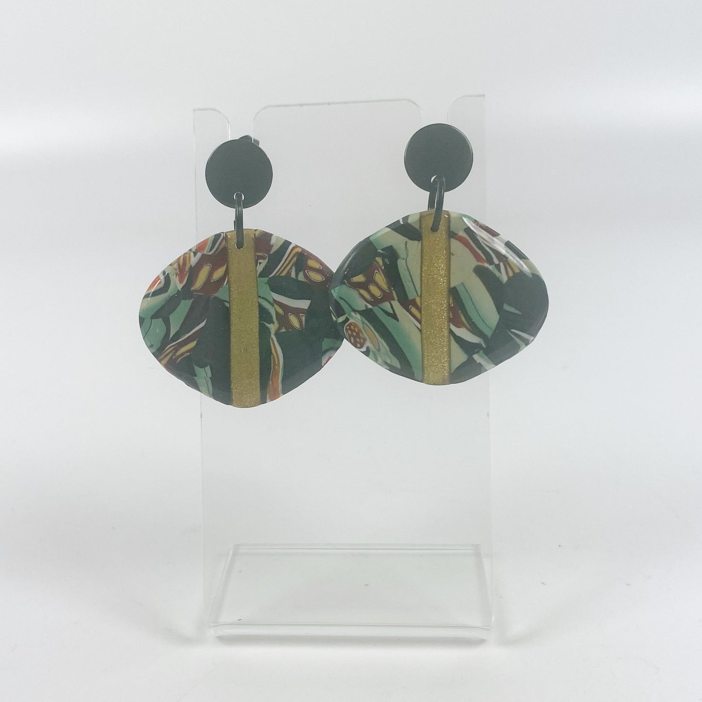 Black Green and Gold Handmade Polymer Clay Dangle Earrings on an acrylic stand