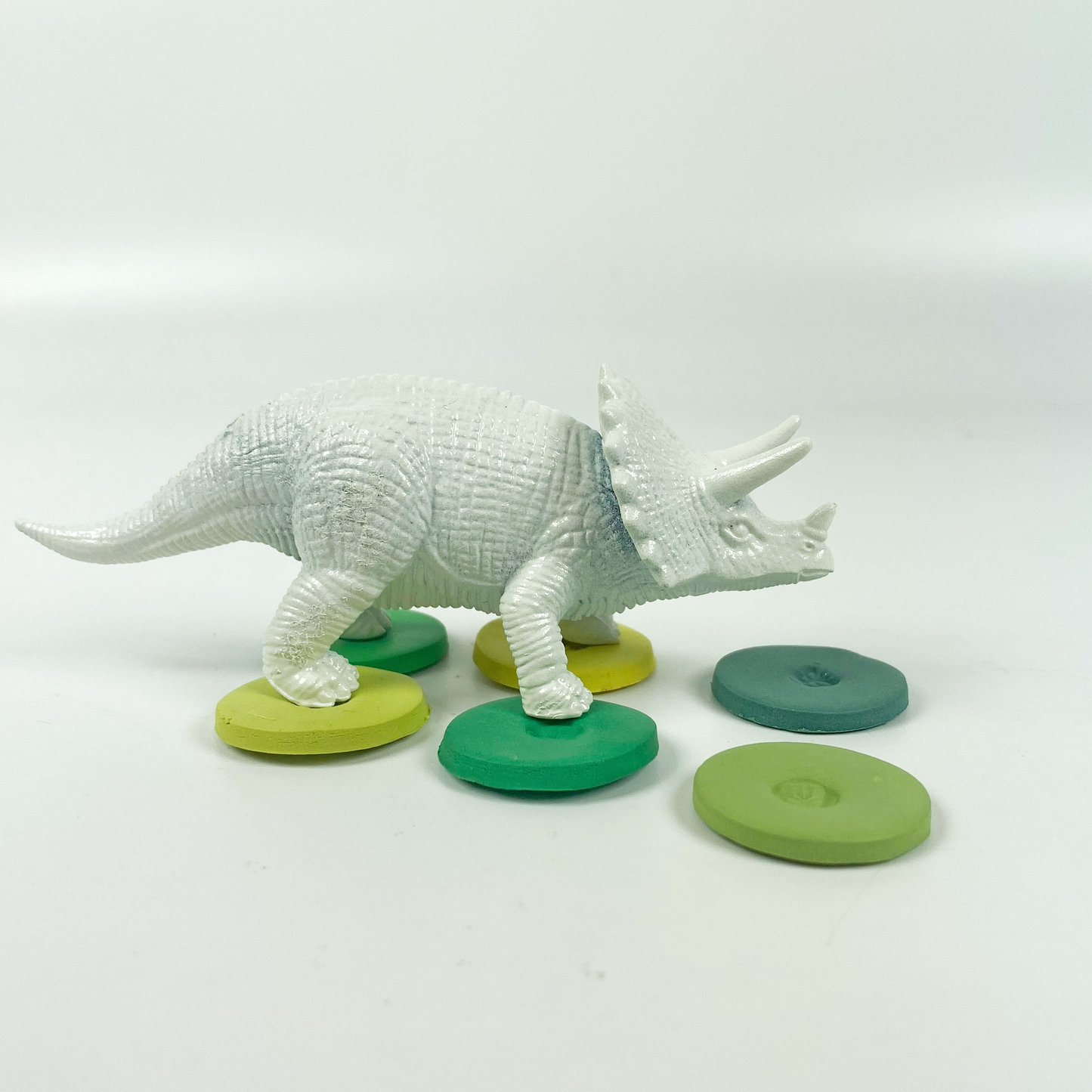 St. Patrick's Day Palette Polymer Clay Color Mixing Tutorial sample color discs as stepping stones for a dinosaur.