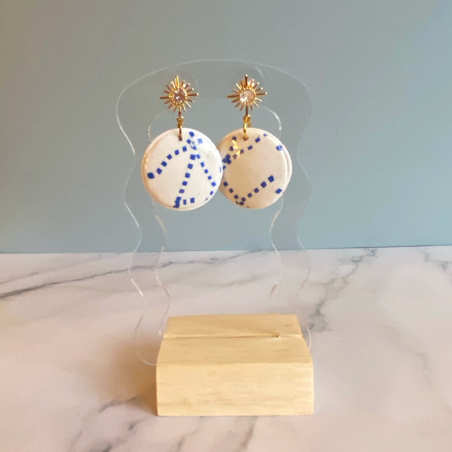 Blue and White Handmade Polymer Clay Dangle Earrings on a clear acrylic stand