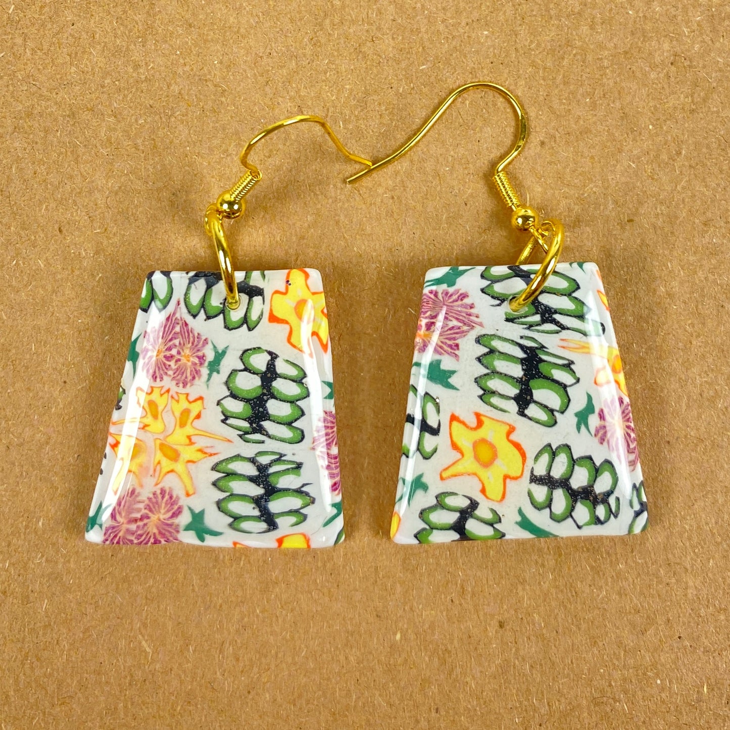 Blossom Burst Handmade Polymer Clay Dangle Earrings front view on warm brown background