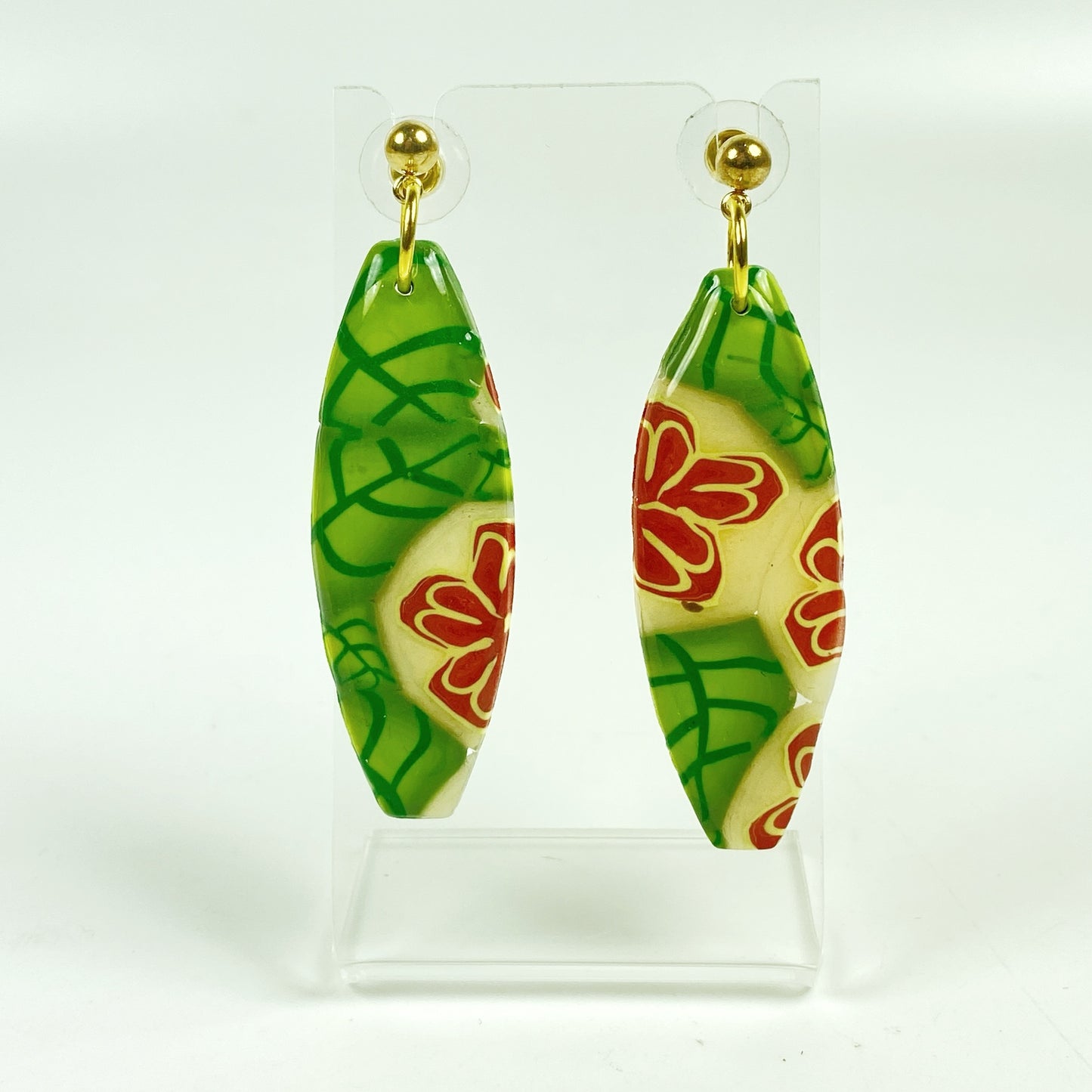 Island Bloom Handmade Polymer Clay Dangle Earrings on a small acrylic display stand