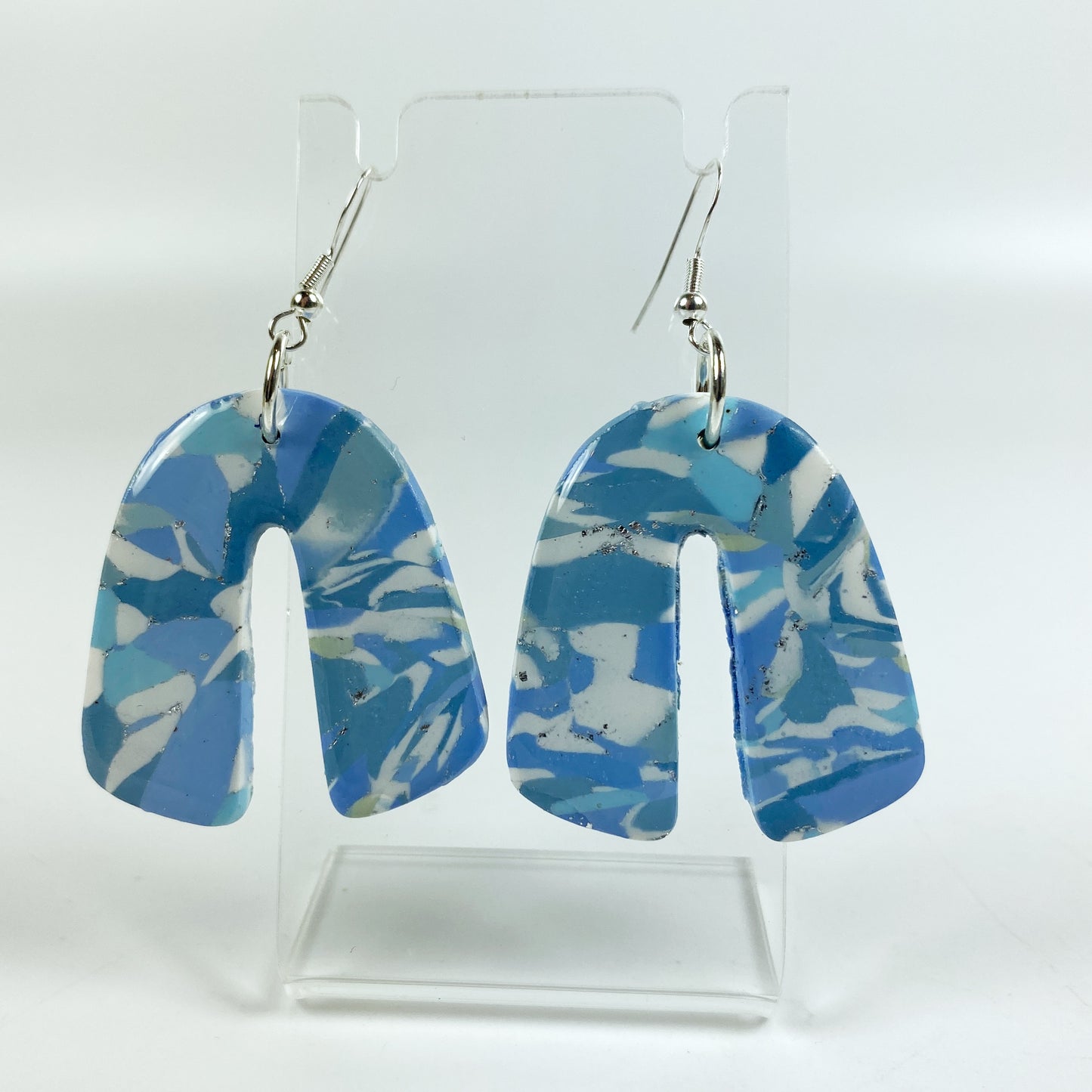 Moody Blue Handmade Polymer Clay Dangle Rainbow Shaped Earrings on acrylic display stand