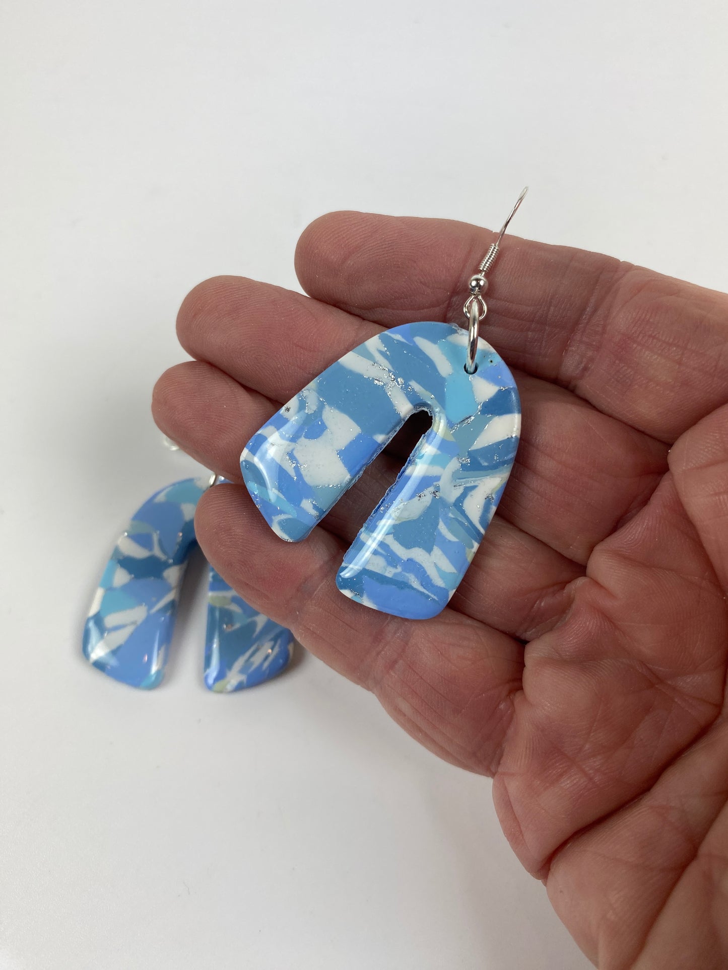 Moody Blue Handmade Polymer Clay Dangle Rainbow Shaped Earrings hand held for size reference