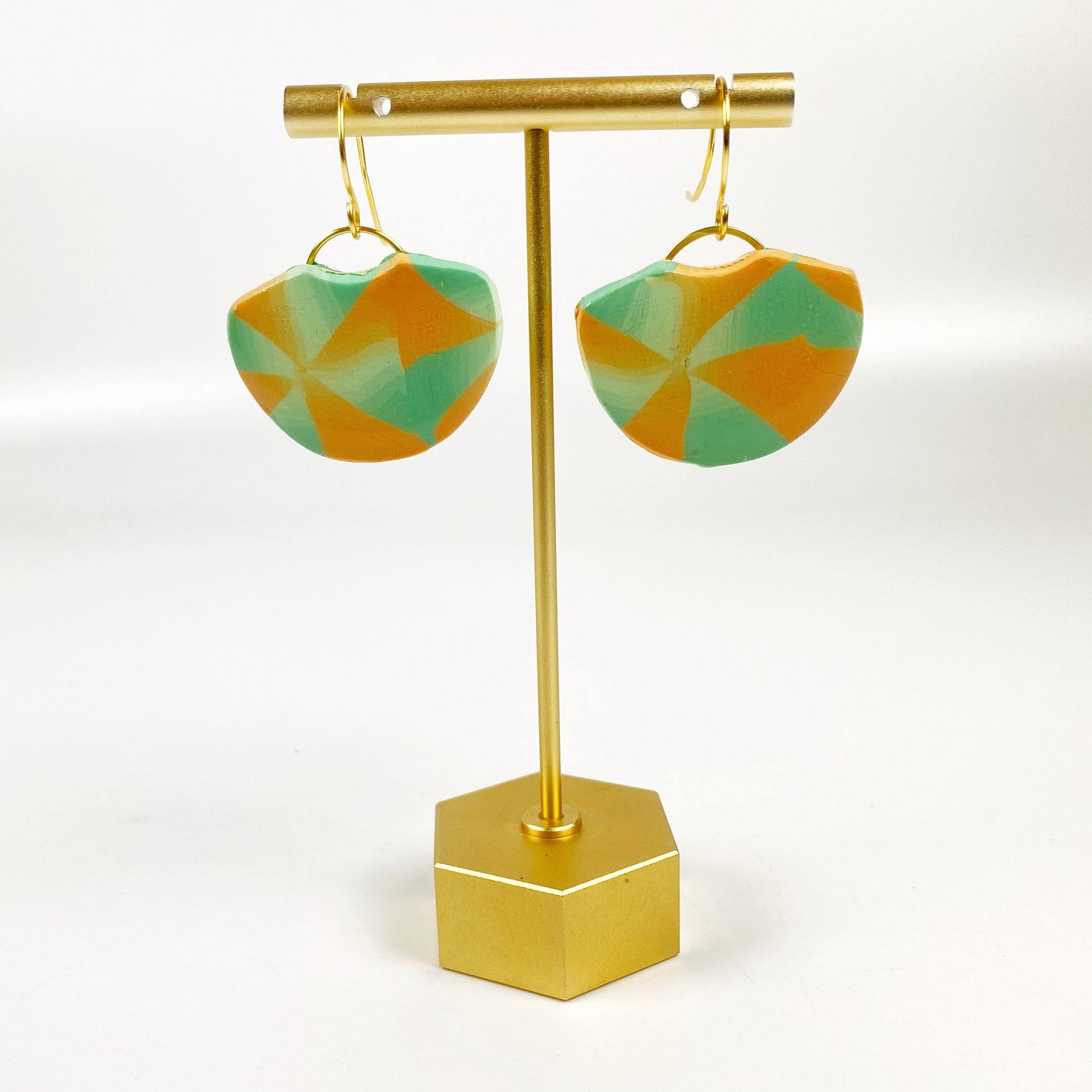 Desert Fan Handmade Polymer Clay Earrings on a brass display stand