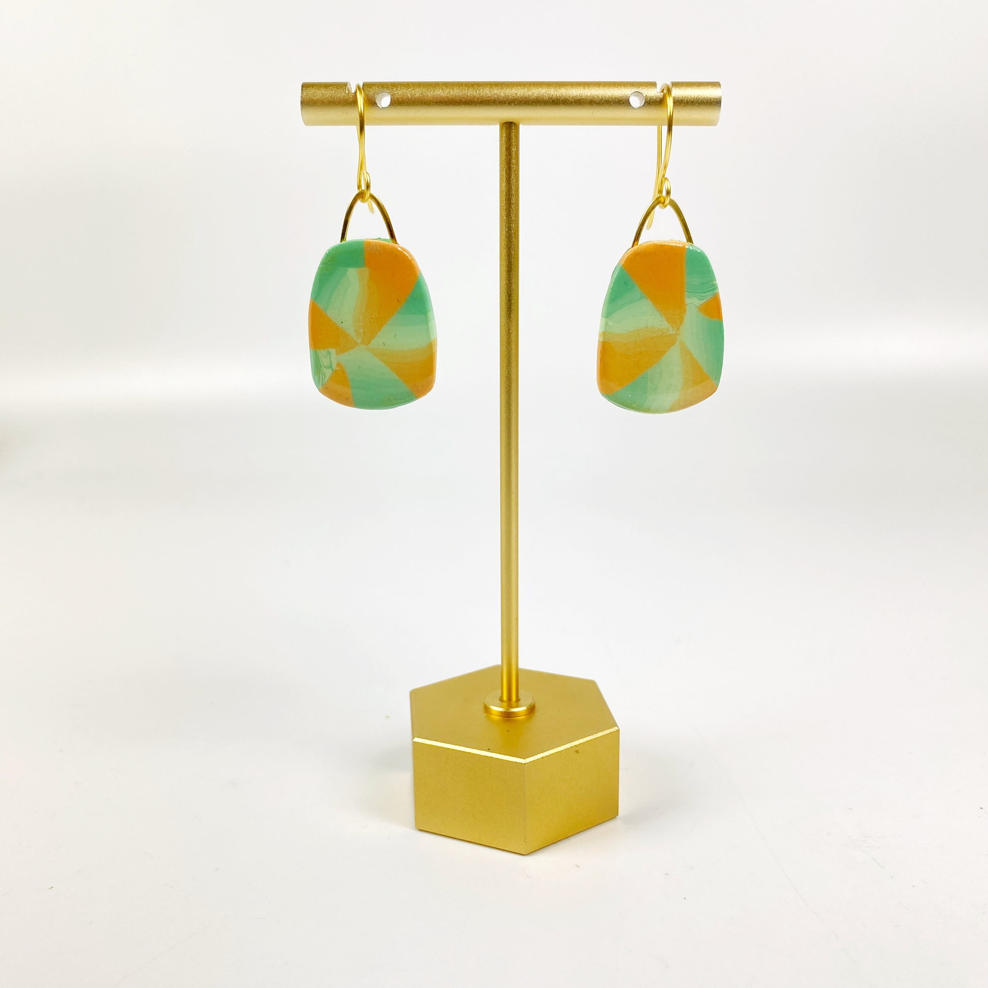 Desert Trapezoid Handmade Polymer Clay Earrings on a brass display stand