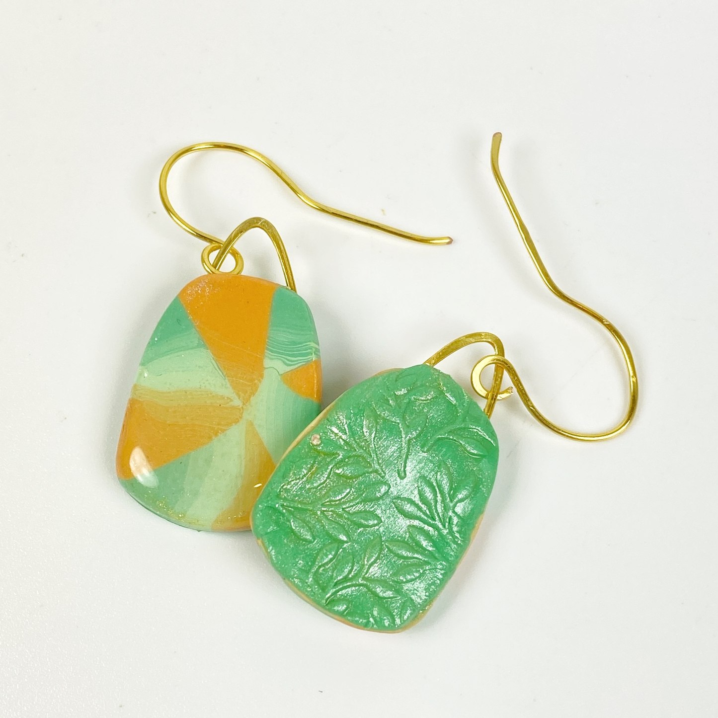 Desert Trapezoid Handmade Polymer Clay Earrings showing the green embossed back side of the earring