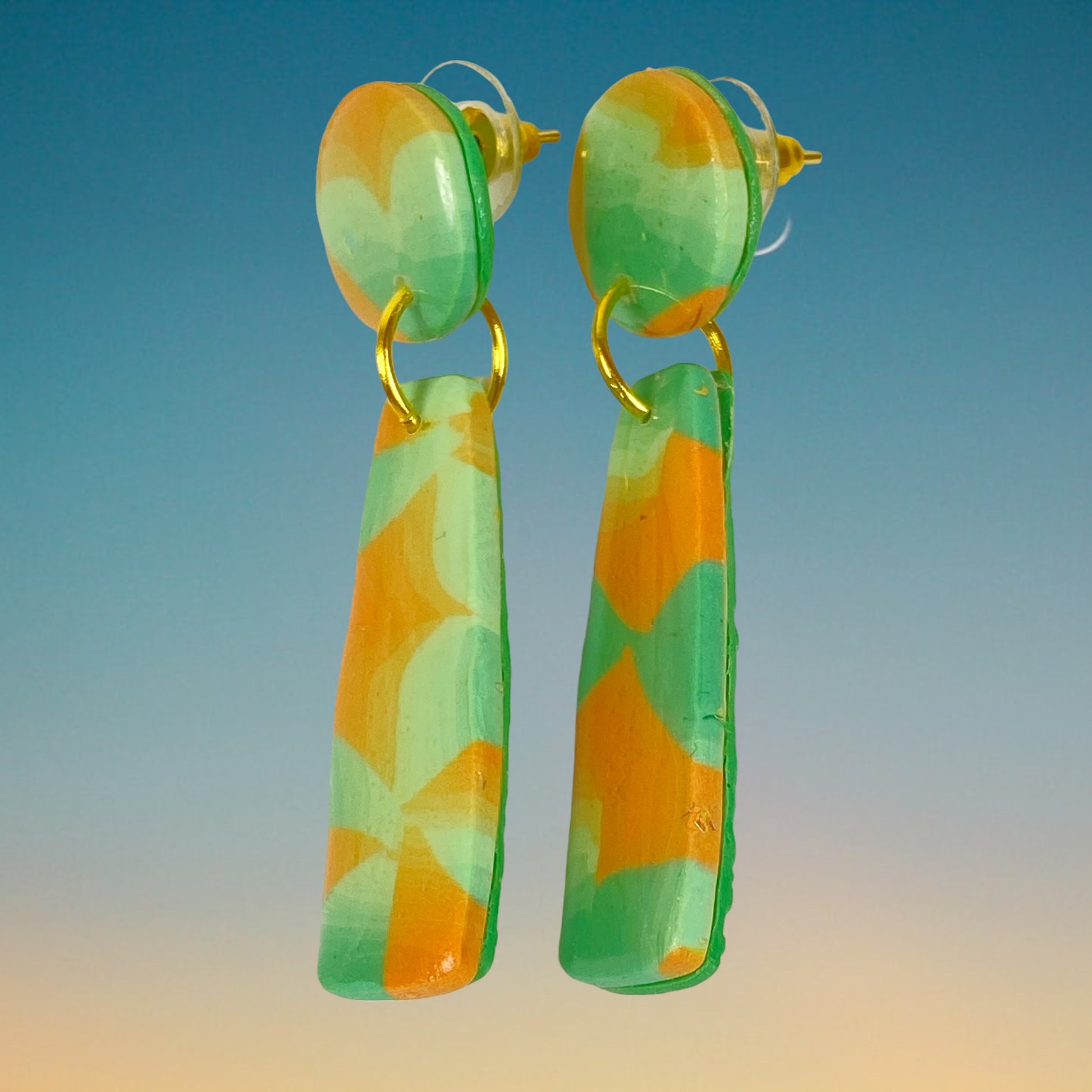 Desert Dangle earrings on a blue gradient background.