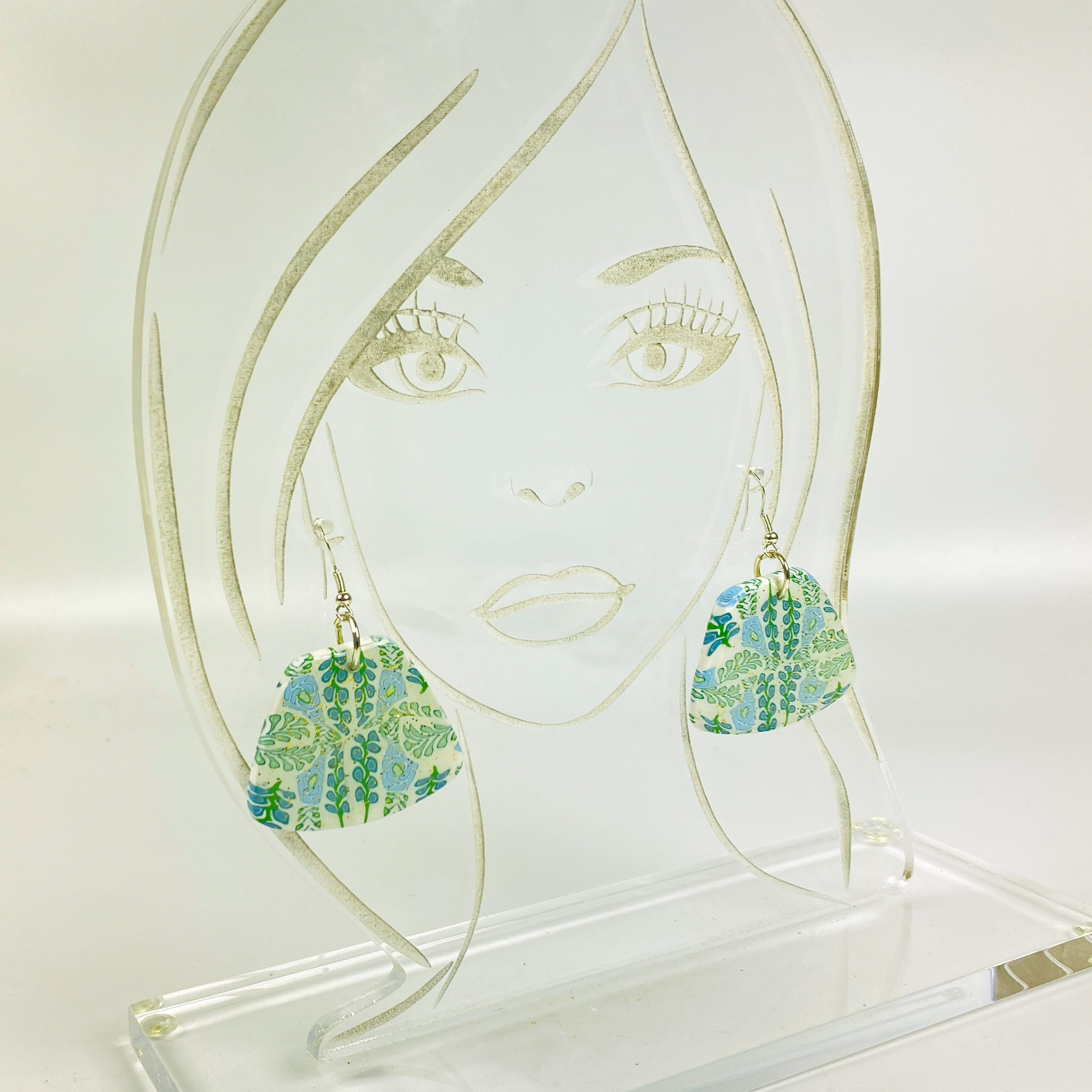 Blue Blossom Handmade Polymer Clay Trapezoid Earrings on an acrylic display head