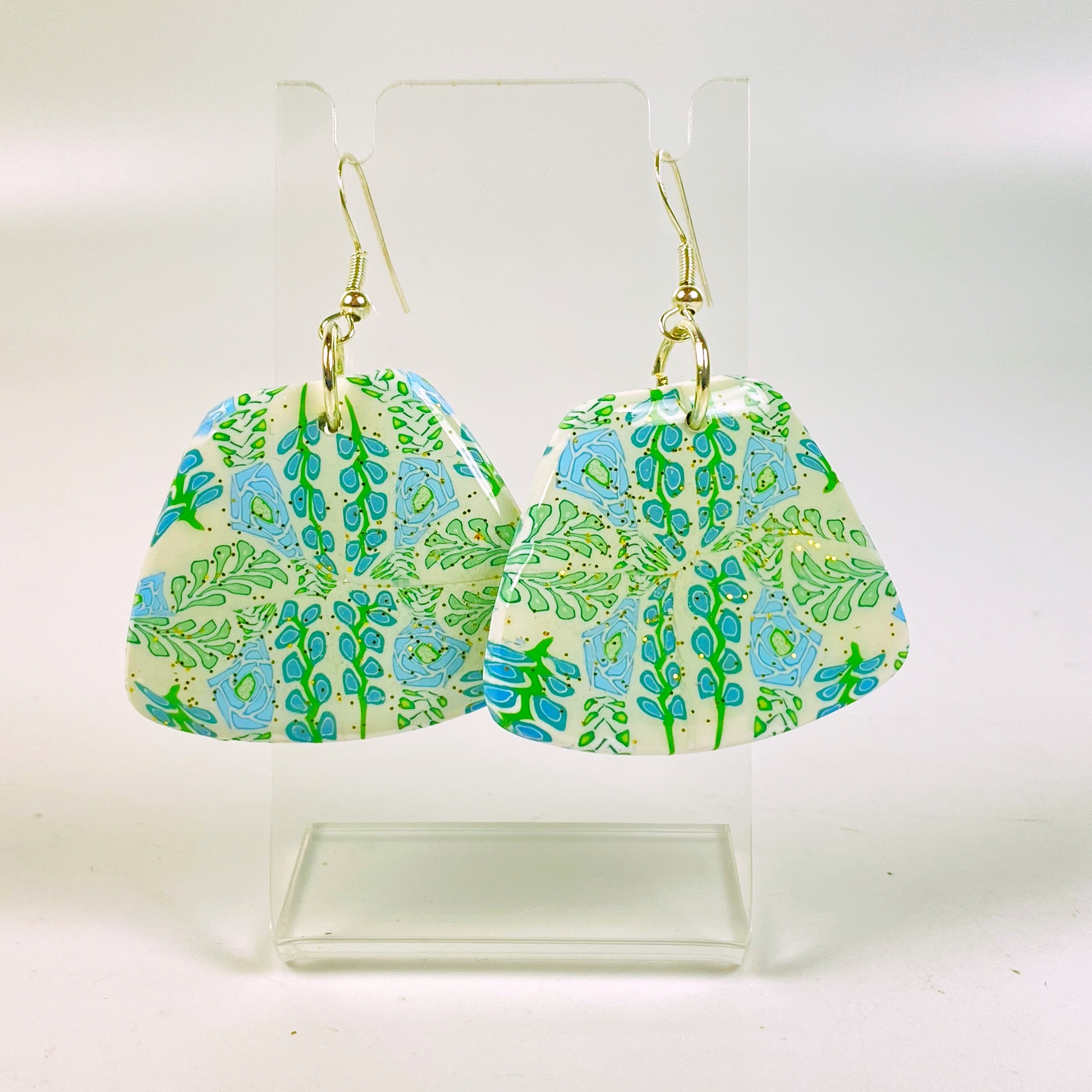 Blue Blossom Handmade Polymer Clay Trapezoid Earrings on a clear acrylic earring stand