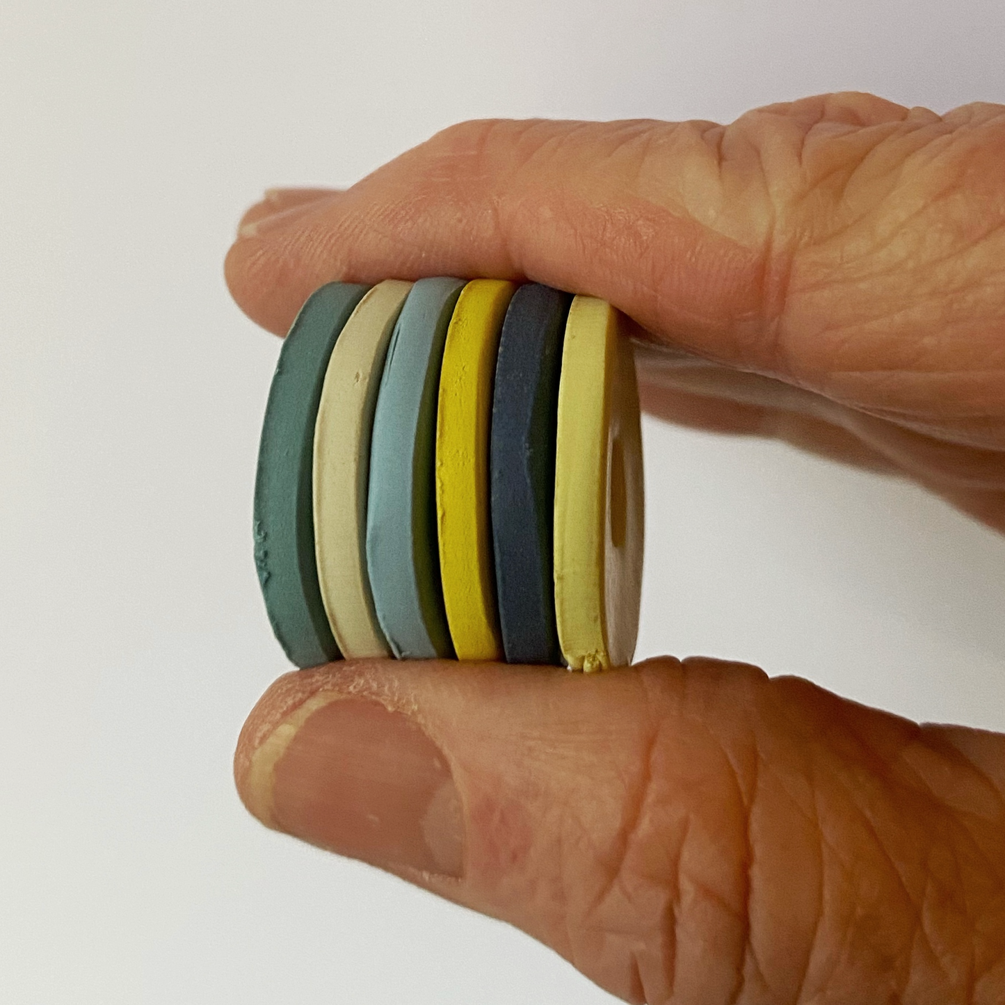A stack of the Provence Evening Polymer Clay Color Sample Discs handheld