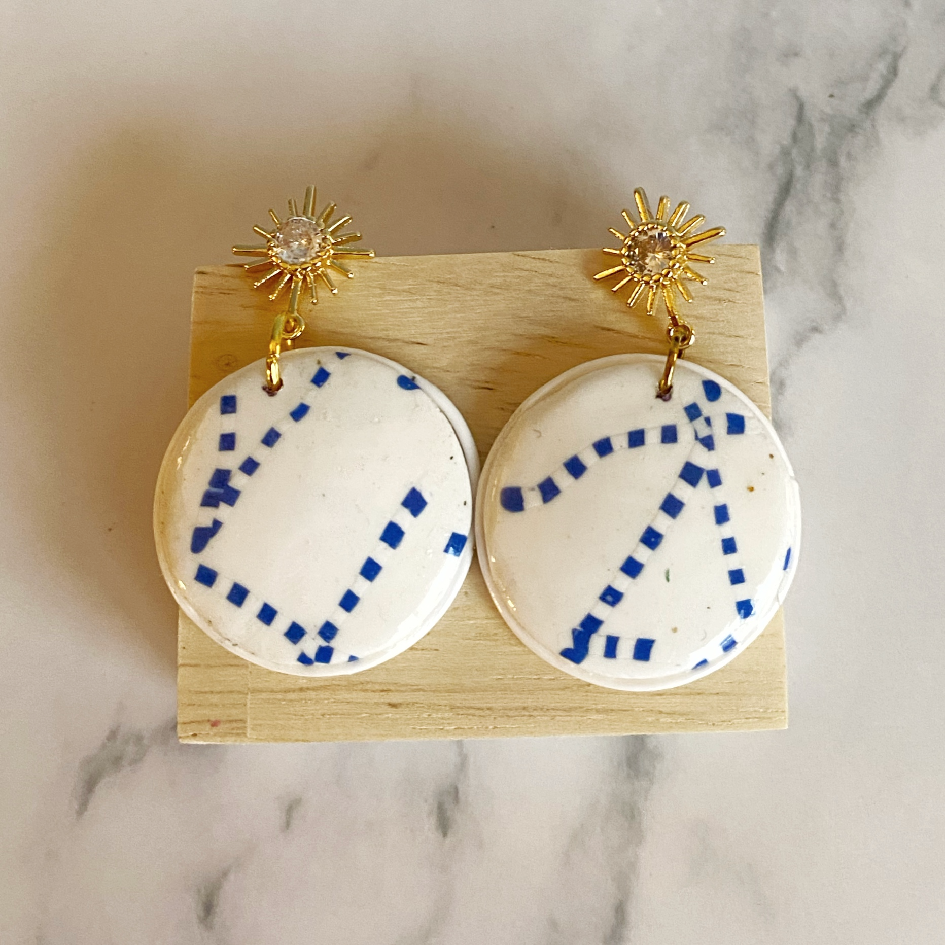 Blue and White Handmade Polymer Clay Dangle Earrings on blonde wood