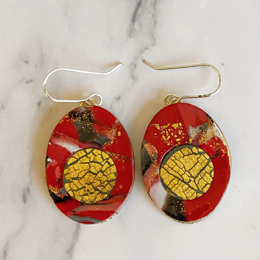 Red Marbled Polymer Clay Earrings with Gold Inset On a marble background.