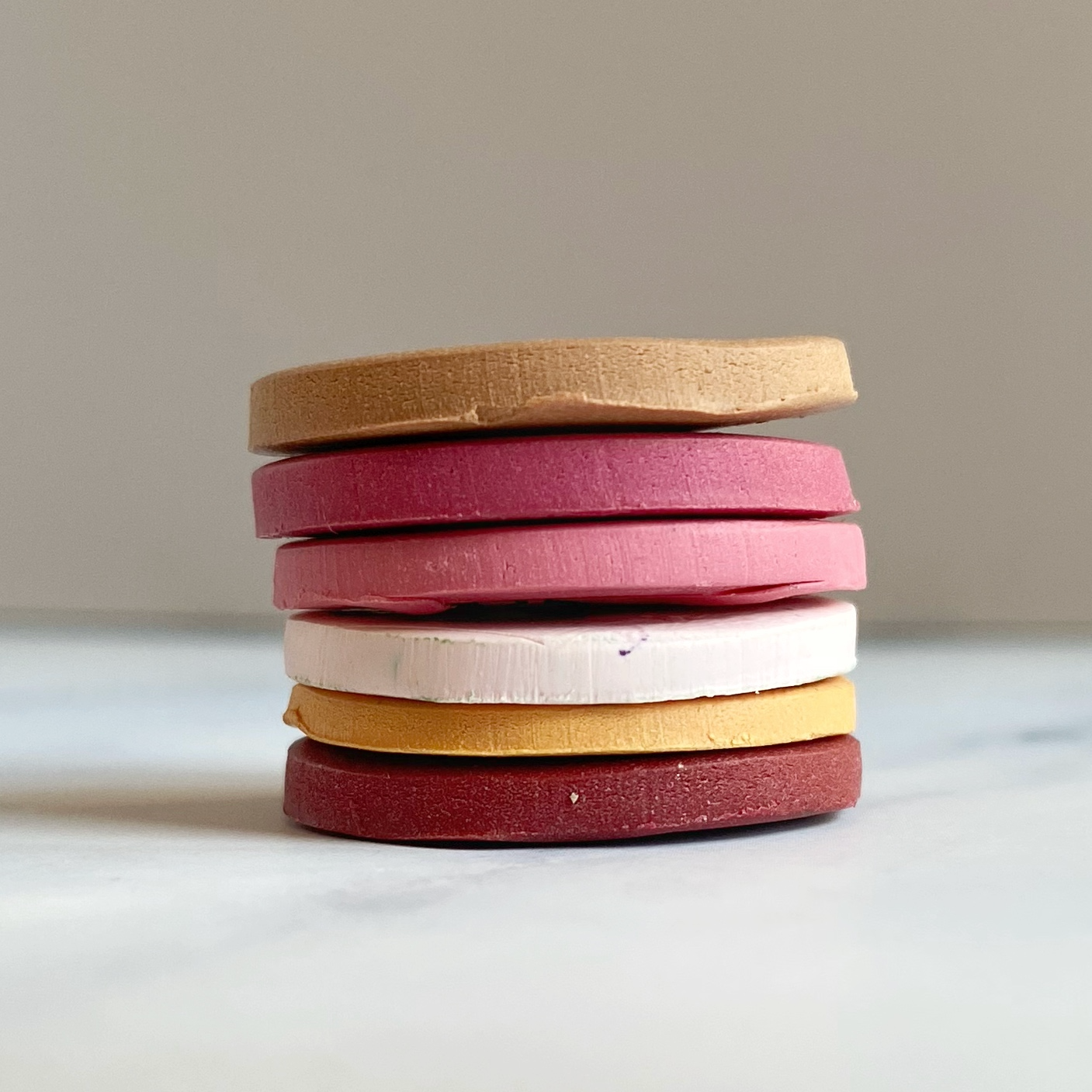In a stack, the sample clay discs in the six colors of this palette