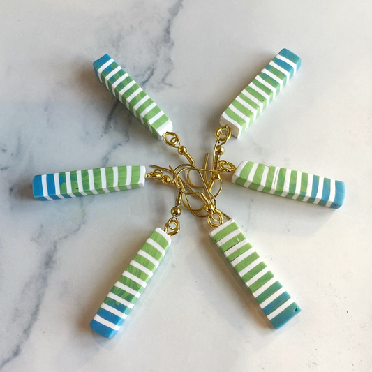 Earrings with green white and blue stripes on a marble background