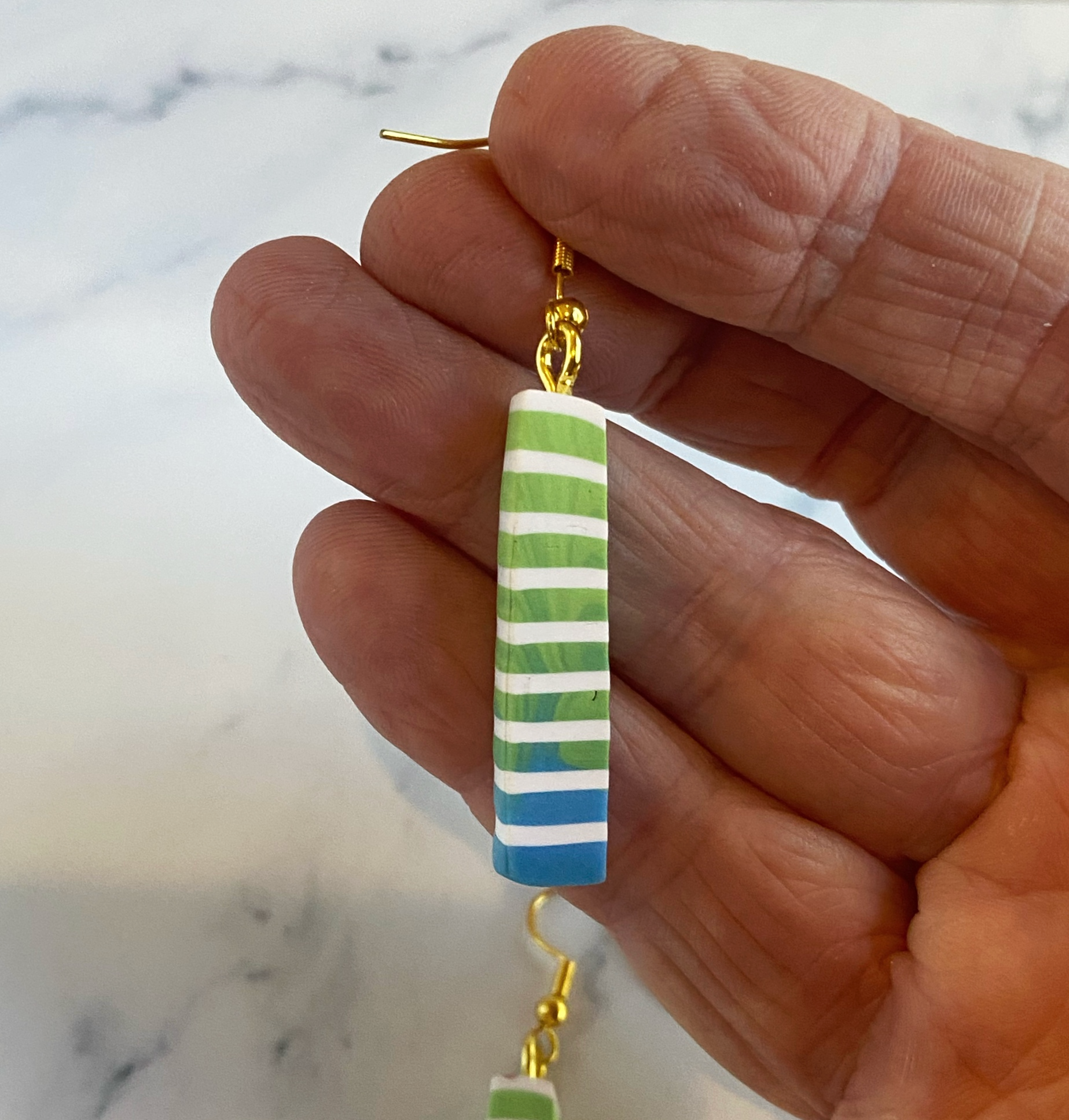 Blue Green and White Polymer Clay Column Earrings hand held for size reference