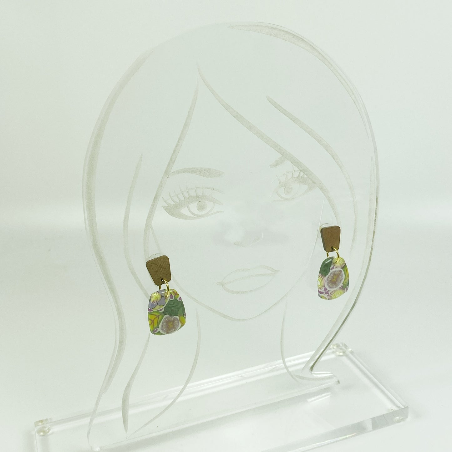 Green Floral Handmade Polymer Clay Dangle Earrings on an acrylic display head