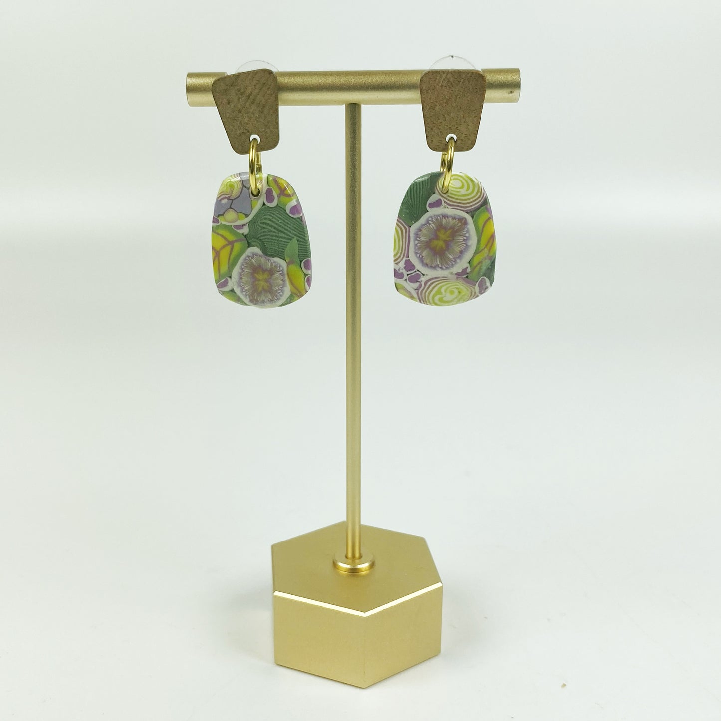 Green Floral Handmade Polymer Clay Dangle Earrings on a brass earring display stand