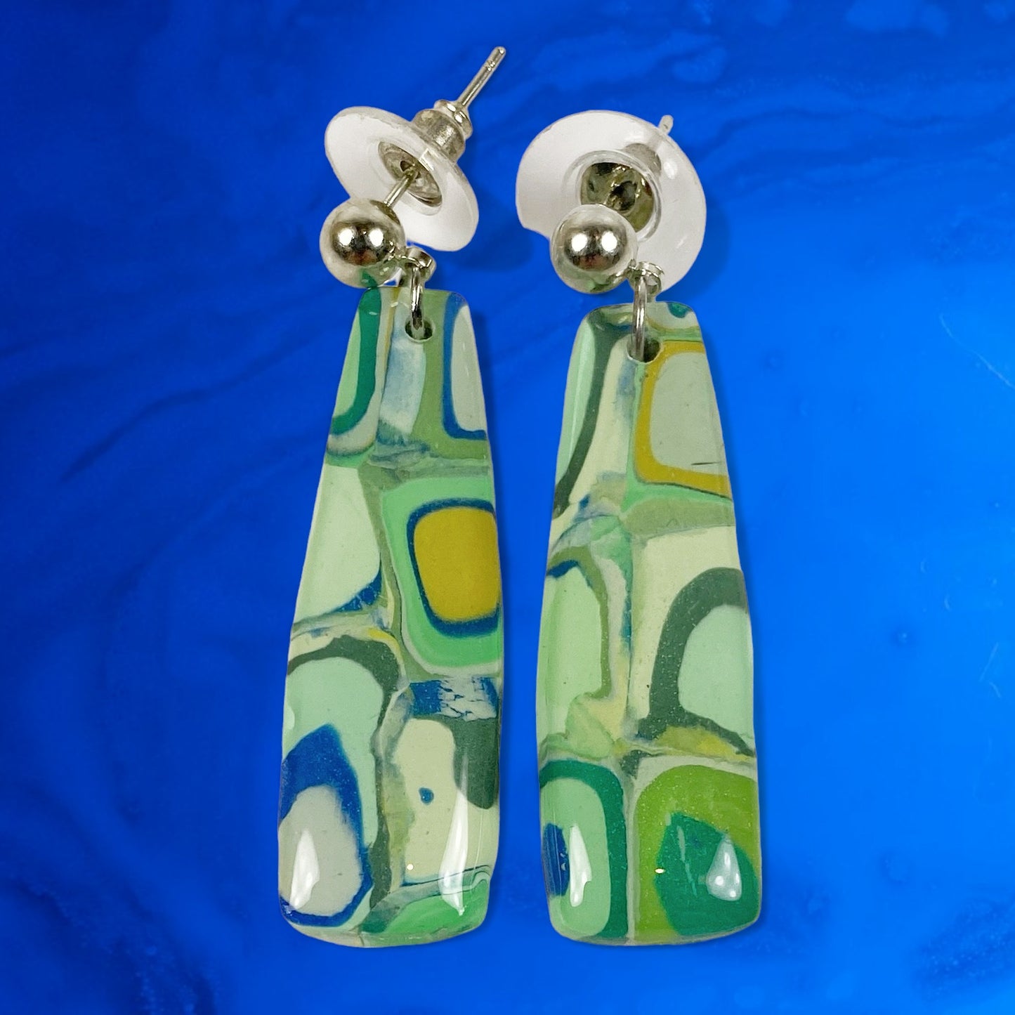 Squares of Green Polymer Clay Handmade Dangle Earrings on a bright blue background