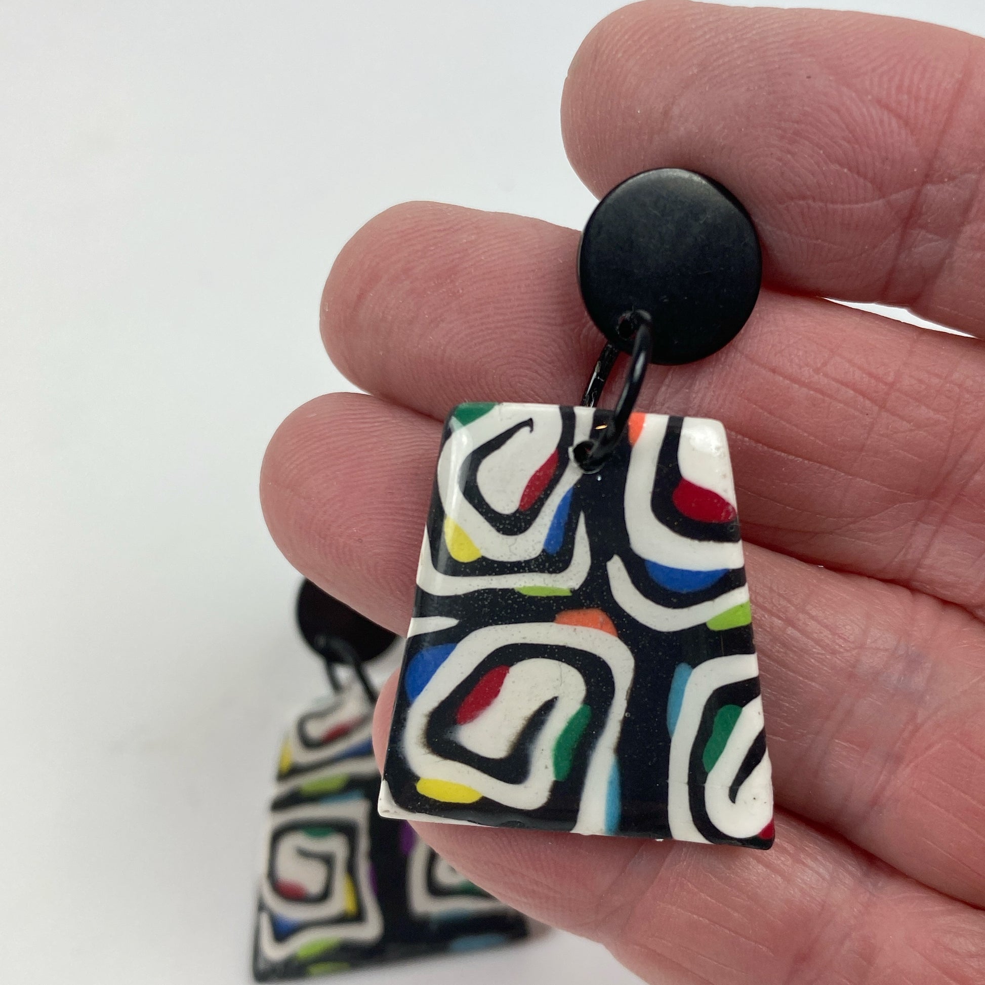 Midnight Spiral Polymer Clay Handmade Dangle Earrings handheld for size reference