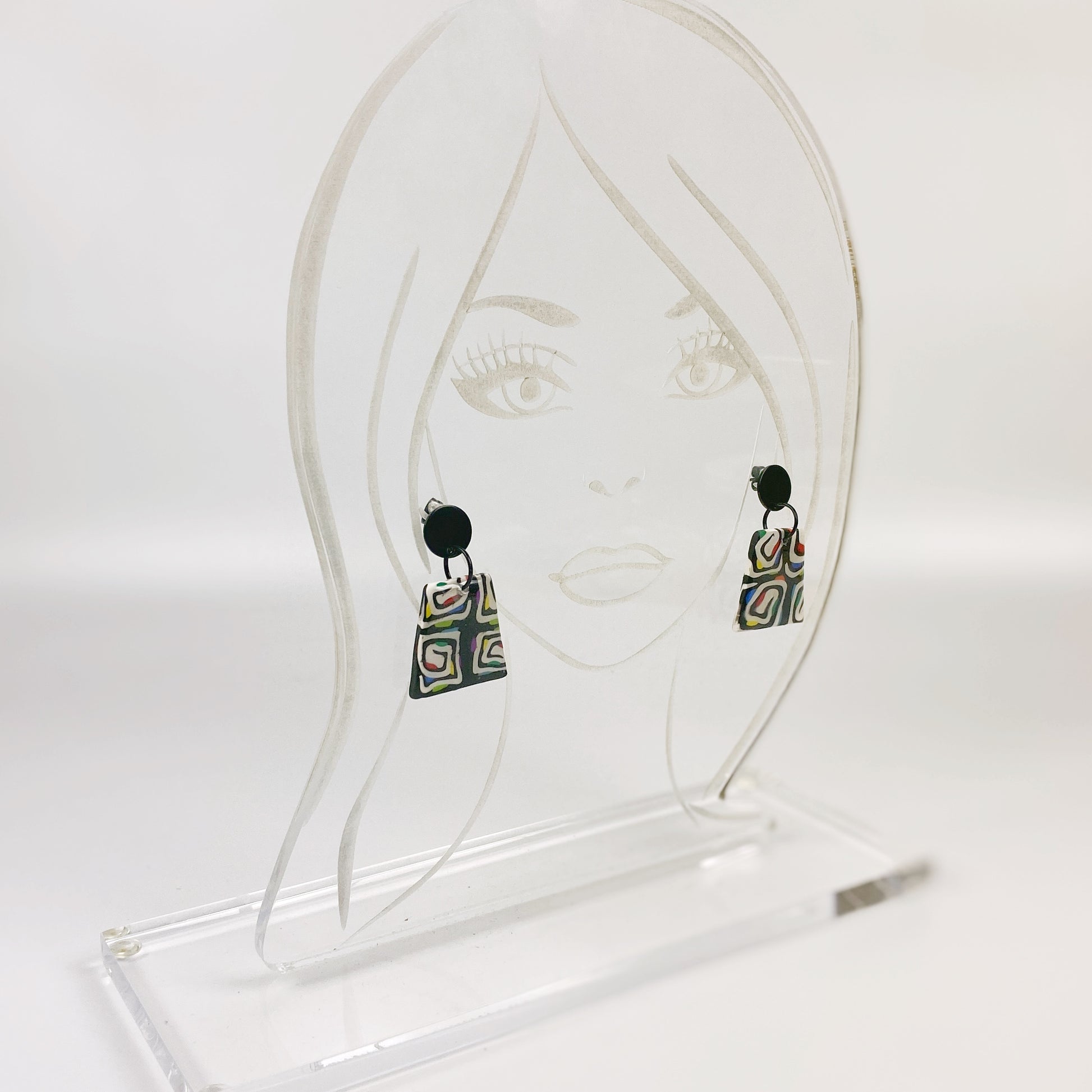 Midnight Spiral Polymer Clay Handmade Dangle Earrings on an acrylic display head