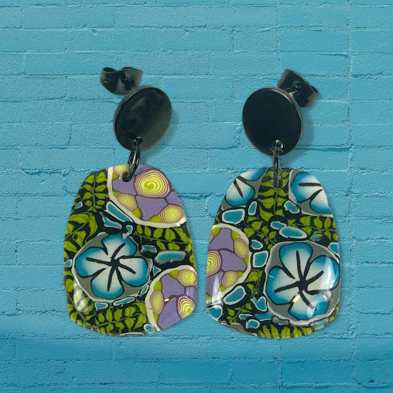 Twilight Blooms Earrings on a blue brick background