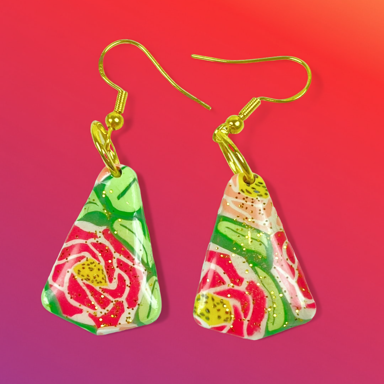 Whispering Roses Handmade Polymer Clay Dangle Earrings on a pink background
