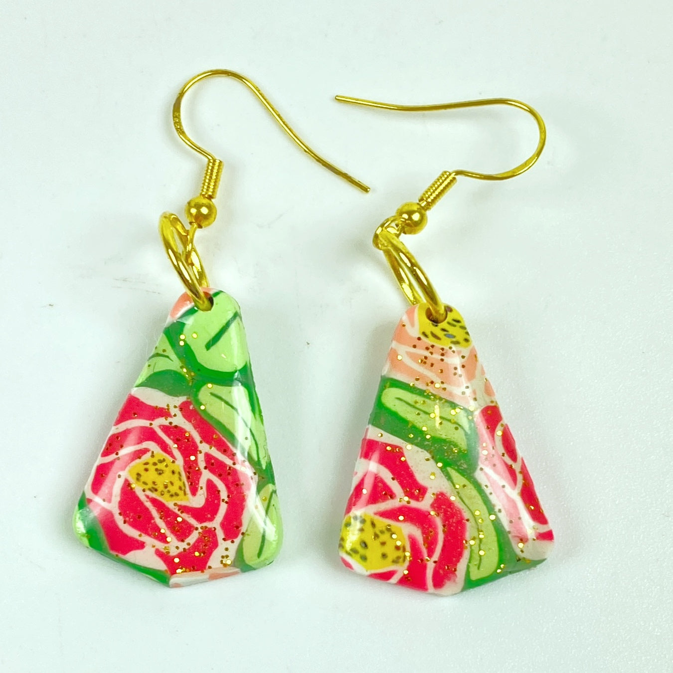 Whispering Roses Handmade Polymer Clay Dangle Earrings on a plain background