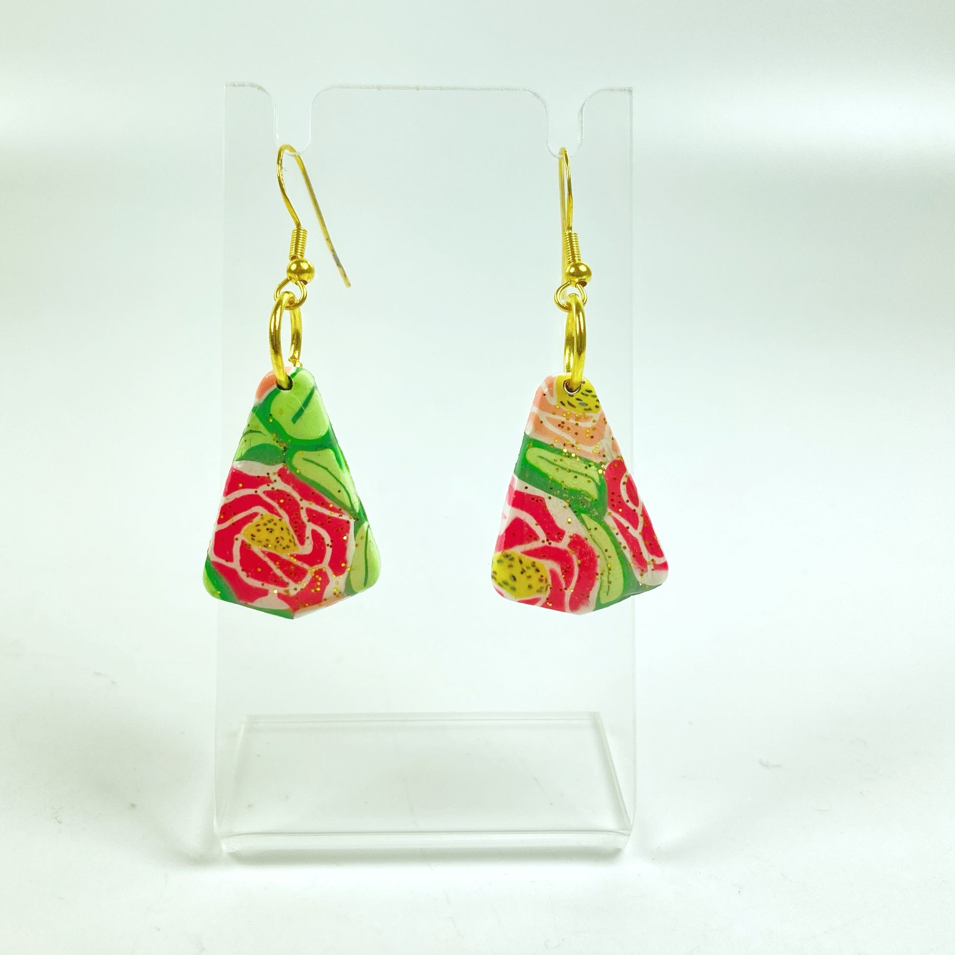 Whispering Roses Handmade Polymer Clay Dangle Earrings on a small acrylic display stand