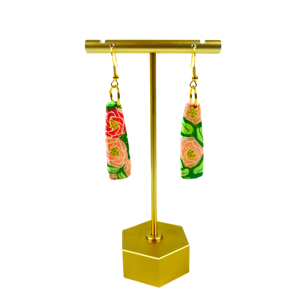 Rose Garden Handmade Polymer Clay Dangle Earrings on a leafy background on a brass earring stand