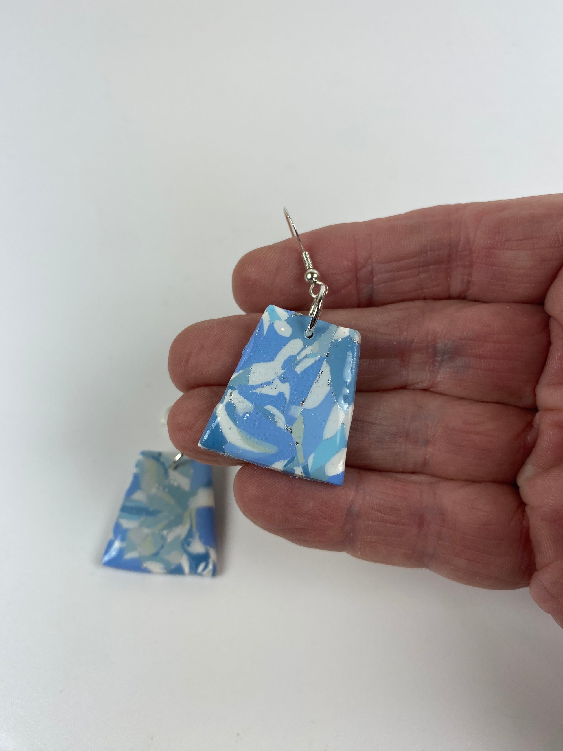 Moody Blue Handmade Polymer Clay Dangle Trapezoid Earrings hand held for size reference