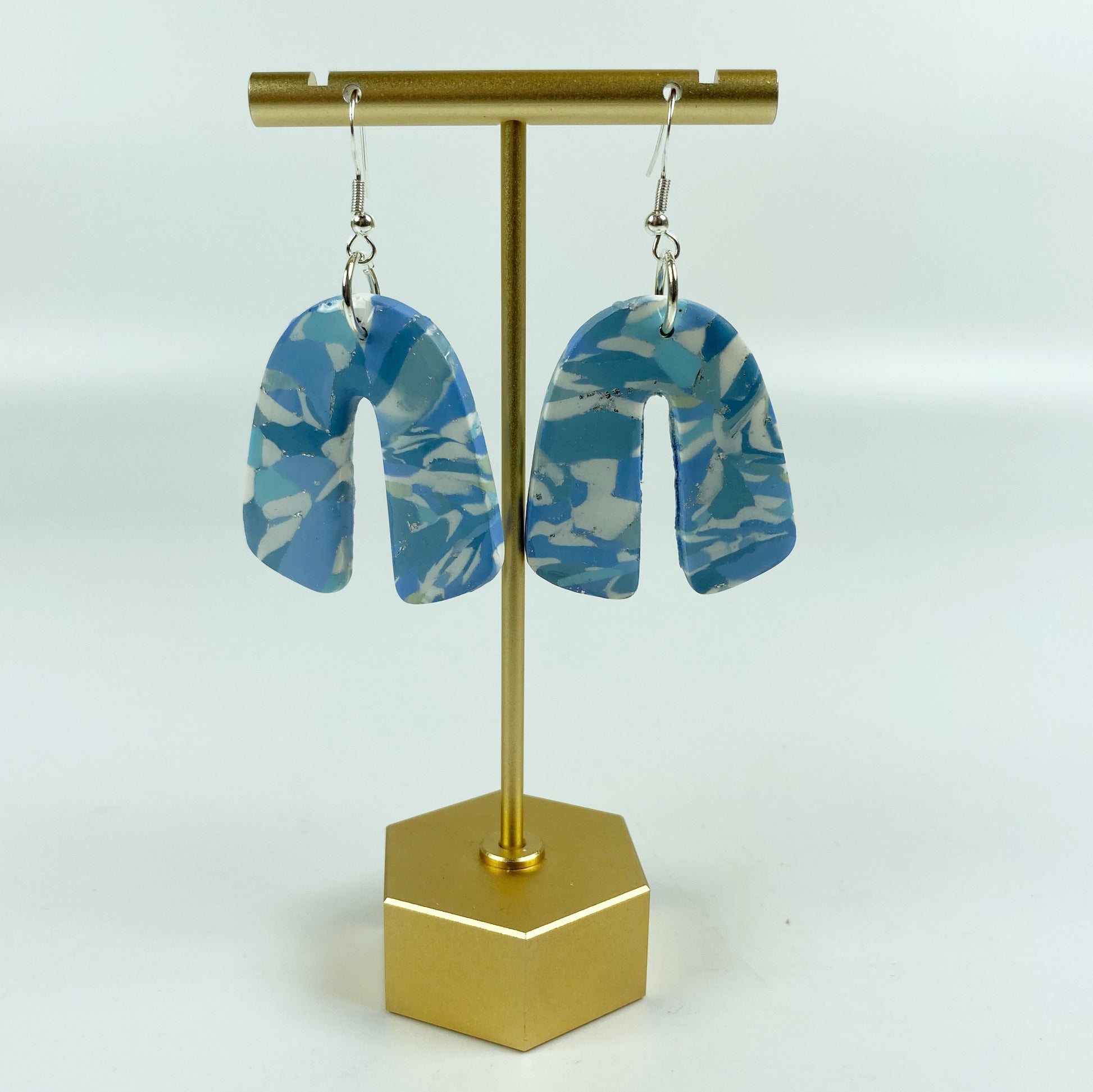 Moody Blue Handmade Polymer Clay Dangle Rainbow Shaped Earrings on brass display stand
