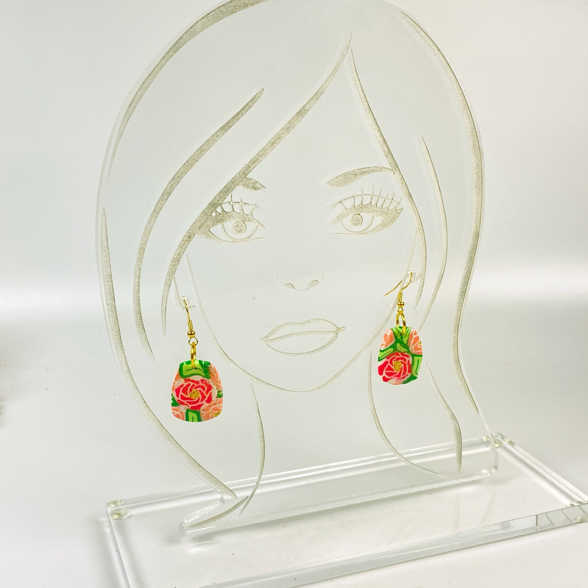 The Roses Handmade Polymer Clay Dangle Earrings on an acrylic display head
