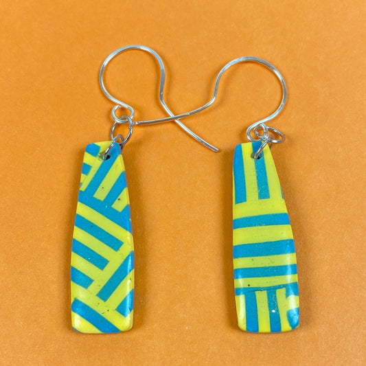 Turquoise & Yellow Braid Handmade Polymer Clay Dangle Earrings front view on an orange background