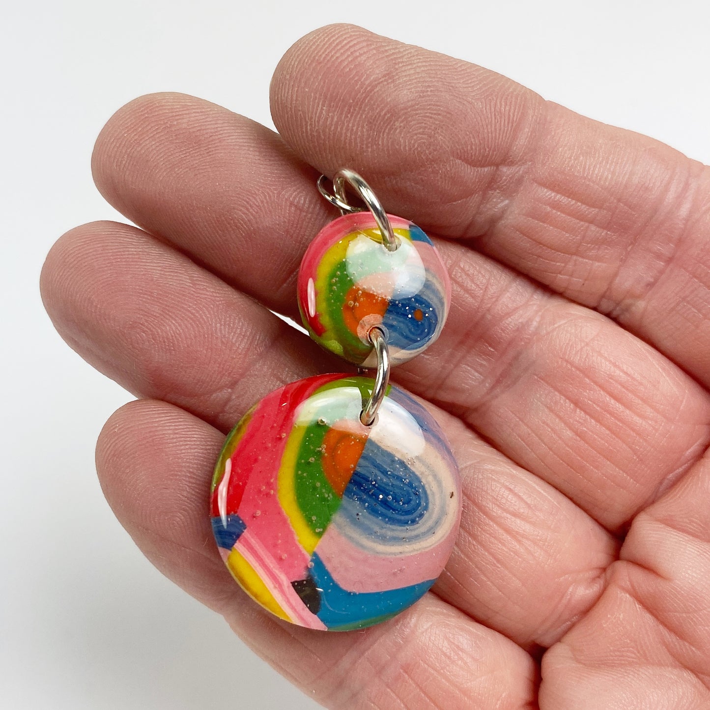 Double Kaleidoscope Multicolor Polymer Clay Dangle Earrings hand held for size comparison