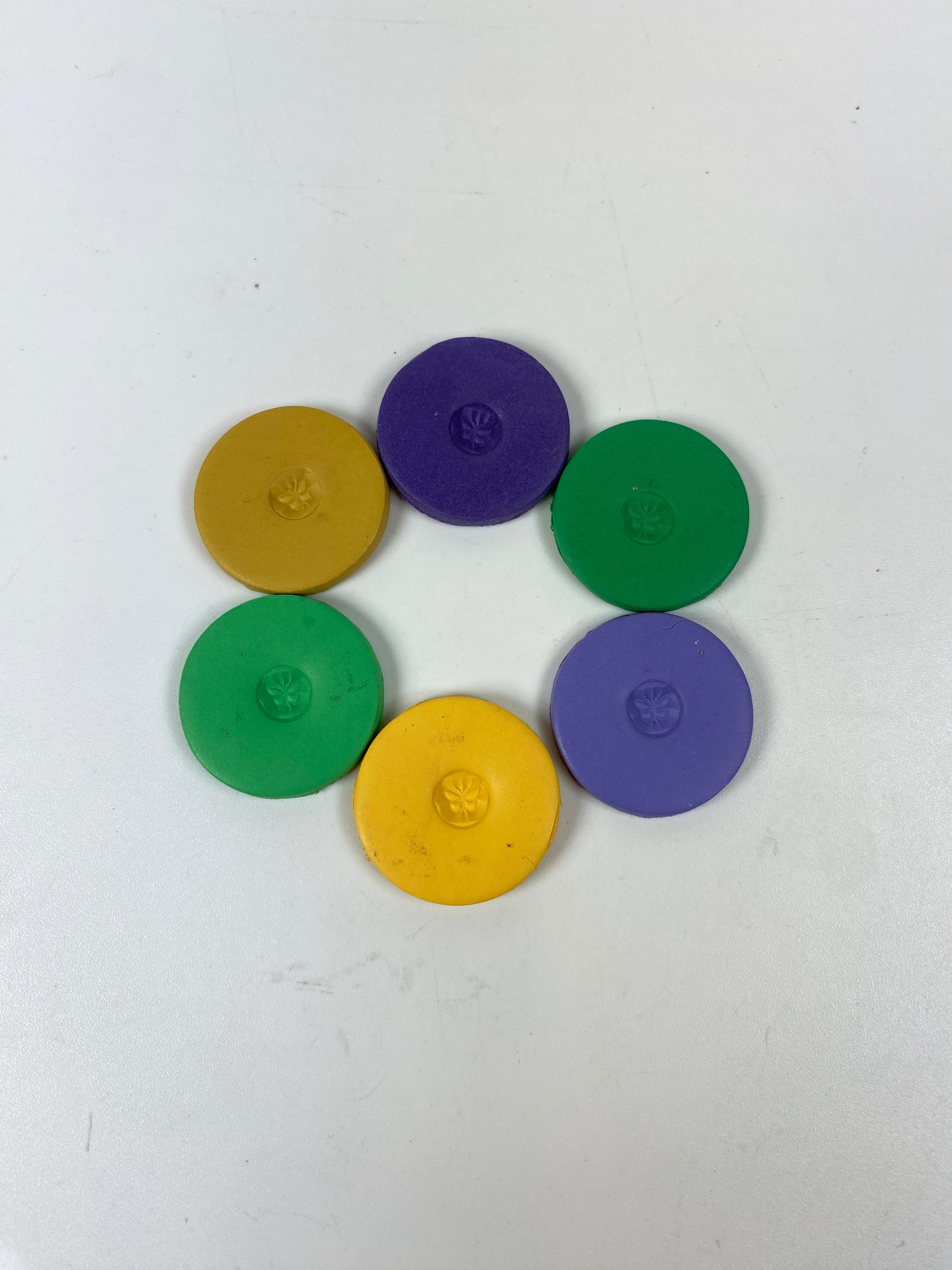 Discs of Polymer Clay in all 6 Mardi Gras colors of this palette, arranged in a ring.